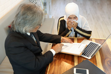 businessman muslim customer complaining muslim seller because of her work is too late with unhappy face and computer while she crying