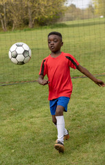 Hampshire, England, UK. April 2019. A young football player defending the goal during a traning session in a public park.
