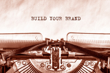 BUILD YOUR BRAND printed on a sheet of paper on a vintage typewriter. writer.