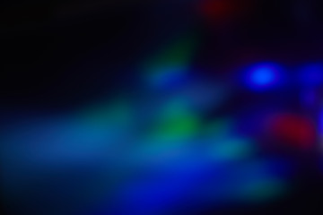 Multicolored blurred spots of light on a dark background.