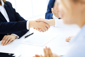 Fototapeta premium Business people shaking hands finishing up a meeting , close-up. Success at negotiation and handshake concepts. Group of lawyers at work