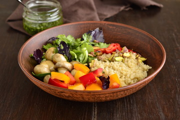 Salad with quinoa, sweet pepper, mushrooms, herbs and pistachios. Healthy nutrition. Vegetarian concept, top view