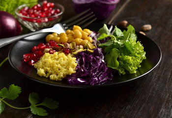 Healthy vegetarian salad. Millet, chickpea, pomegranate seeds, red cabbage, onions, arugula. Buddha bowl.