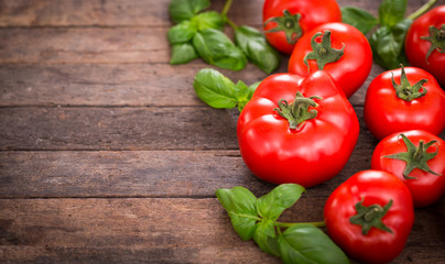 Fresh ripe tomatoes and basil on the wooden table