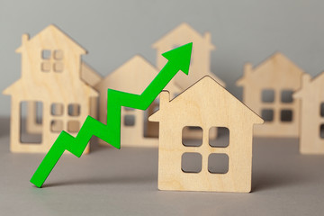 Up arrow and many houses. Growth in real estate prices market. Buying and selling house