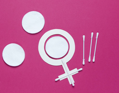 Products for feminine hygiene, self-care and health, female gender symbol on a red background. Ear sticks, pads. Top view