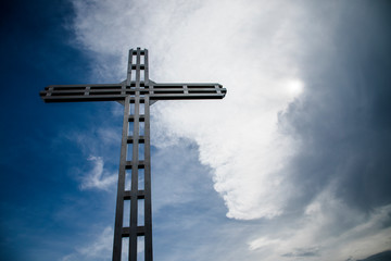 A Christian cross, a background of clouds and sunshine