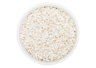 White bowl of raw organic arborio risotto rice on white background. Healthy food.