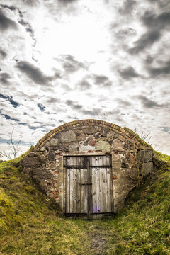 Old dug-out building under a cloudy sky