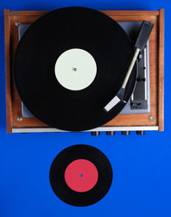 Obraz premium Retro vinyl record player, lp record on blue background. Top view. Retro style. Flat lay.