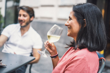 Brunette woman drinking white wine. Adult friends relaxing drinking wine concept