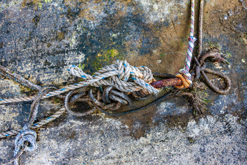 Ropes and rusty steel bar at an old harbour.