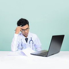 Asian young man doctor in uniform has stress  in his office at the hospital