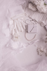 Fototapeta na wymiar White bridal accessories for wedding background with pearls, white satin ribbons and lace, gloves, bracelet,flat lay for fashion blog, top view