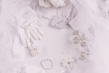 White bridal accessories for wedding background with pearls, white satin ribbons and lace, gloves, bracelet,flat lay for fashion blog, top view