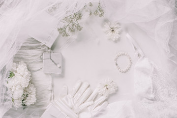 White bridal accessories for wedding background with pearls, white satin ribbons and lace, gloves, bracelet,flat lay for fashion blog, top view