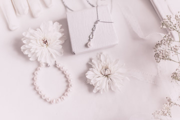 White bridal accessories for wedding background with pearls, white satin ribbons and lace, gloves, bracelet,flat lay for fashion blog, top view