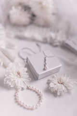 White bridal accessories for wedding background with pearls, white satin ribbons and lace, gloves, bracelet,flat lay for fashion blog, top view