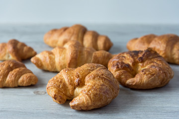 Close Up of Fresh Baked Croissant on wood table with Coffee Mug and  news paper on Relaxing Morning at Home, Bread and coffee, breakfast Healthy food of the city life