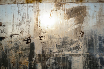 Abstract background. Window chaotically smeared with paint, illuminated by the sun.