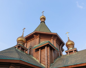 New wooden Orthodox church, dome with a cross and blue sky. Russia.