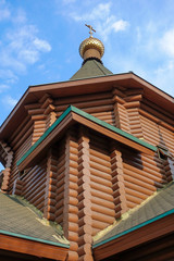 New wooden Orthodox church, dome with a cross and blue sky. Russia.