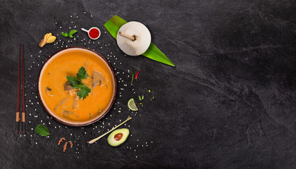Yellow curry asian food background with various ingredients on stone table.