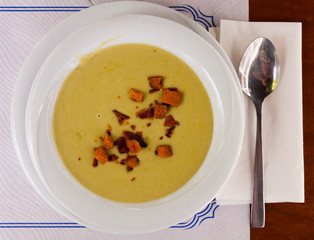 Top view of vegetable cream soup with croutons