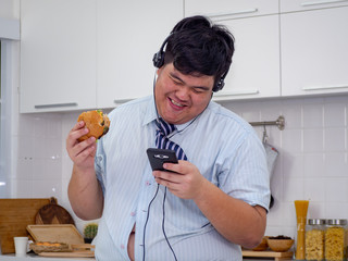 young asian fat man enjoy eating while listen music