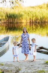 Fototapeta premium Mother and two daughter having fun in the park. Beauty nature scene with family outdoor lifestyle. Happy family concept. family resting together. Mother's day concept