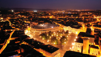 Aerial drone night shot from iconic illuminated Arena theatre and City Hall in Bra square of beautiful city of Verona, Lombardy, Italy © aerial-drone