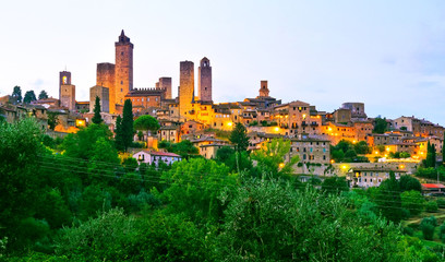 Fototapeta premium View of the historic cityscape of San Gimignano facing the countryside in Tuscany, Italy at dusk.