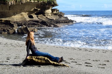 Girl sitting on New Zealand beach