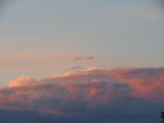 Pink and blue grey romantic clouds lit by the evening sun. Background texture