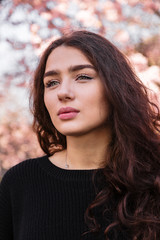 Girl with flowing hair against blooming tree