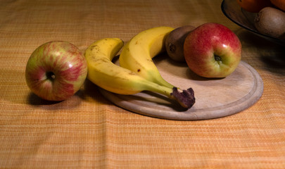 fruit on the kitchen table. bananas and apples, kivi.