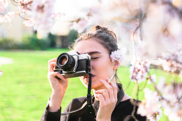 Girl with camera and cigarette in hand looks slyly