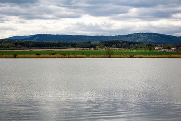 Pond with hill Klet and cloud sky, Czech landscape