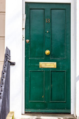 Entire house door number 13 with the thirteen on a green wooden door