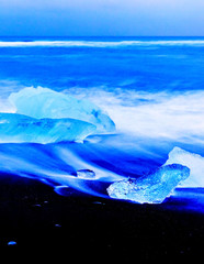 View of the icebergs flowed from the Jokulsarlon Glacier Lagoon to beachside in Iceland at twilight in winter.