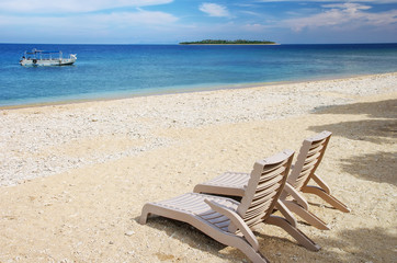 Fototapeta na wymiar Sun chairs on white sandy beach