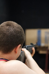 Man shooting a rifle from the back