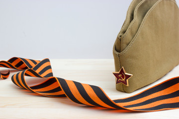 Victoru day composition with soviet flight cap and Saint George ribbon