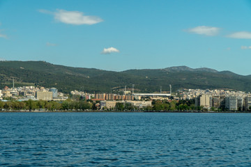 Fototapeta premium Thessaloniki / Greece 11 April 2019 the blue sea and the white tower of thessaloniki city's symbol and landmark ,beautiful sunny day after long time of rain and clouds great opportunity for a walk.