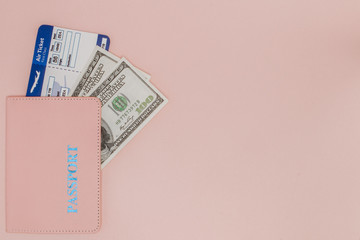 Passport, dollars and air ticket on a pink background. Travel concept, copy space