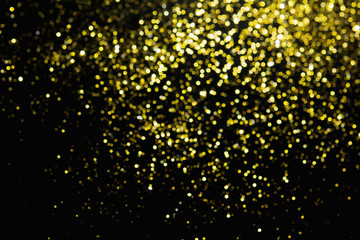 Abstract blurred glitter bokeh background in gold, on black