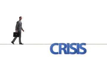 Crisis concept with businessman walking on tight rope