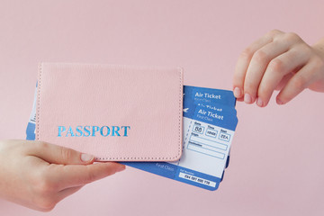 Close up tourist female horizontal hold in hand tickets for plane with orange passport, boarding pass, isolated on yellow background. Copy space advertising area. Air flight journey concept