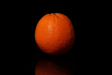 Oranges fruit on a black background with reflection