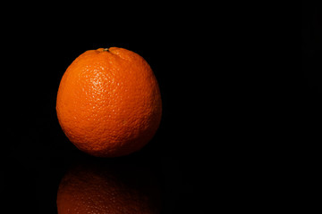Oranges fruit on a black background with reflection